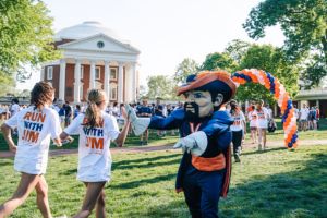 students high fiving cavman in front of the rotunda