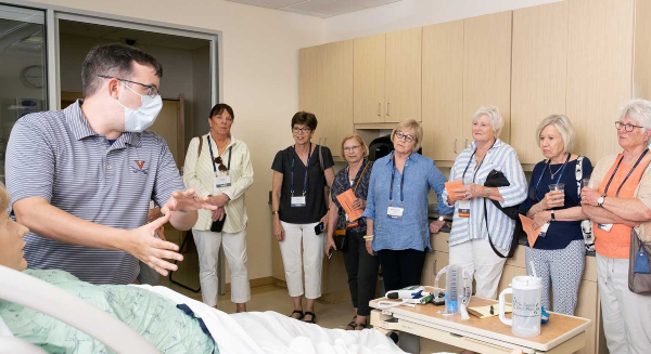 Nursing volunteers receiving instruction at a hospital bedside