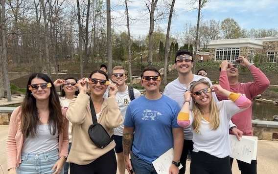 MBA students with eclipse glasses