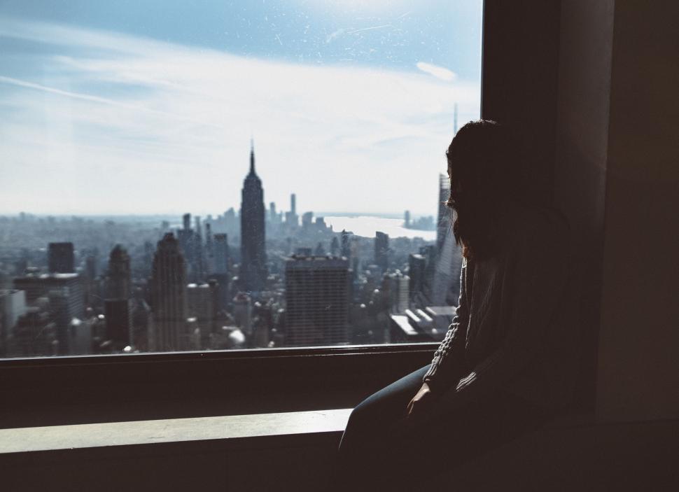 Person looking out the window at a city